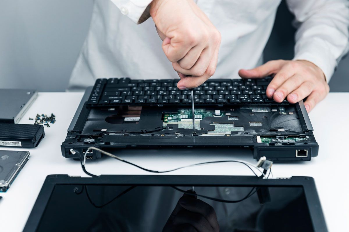Data Recovery Services – Laptop Repair and Diagnostics Technician performing data recovery on a disassembled laptop