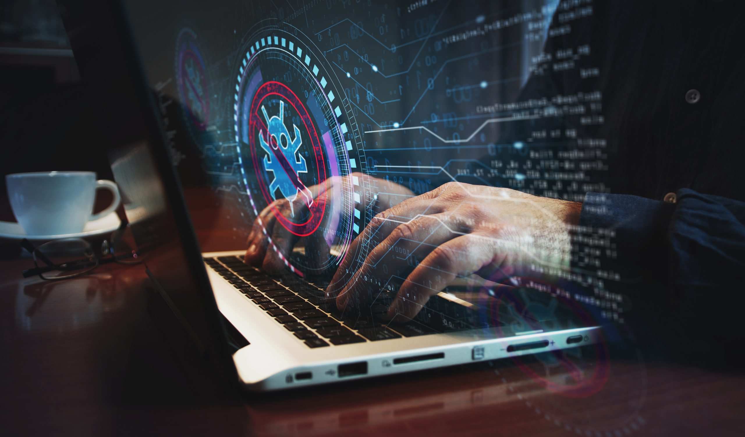 Comprehensive Virus and Malware Protection Hands typing on a laptop with a glowing digital overlay showing a malware icon crossed out, symbolizing virus and malware protection.