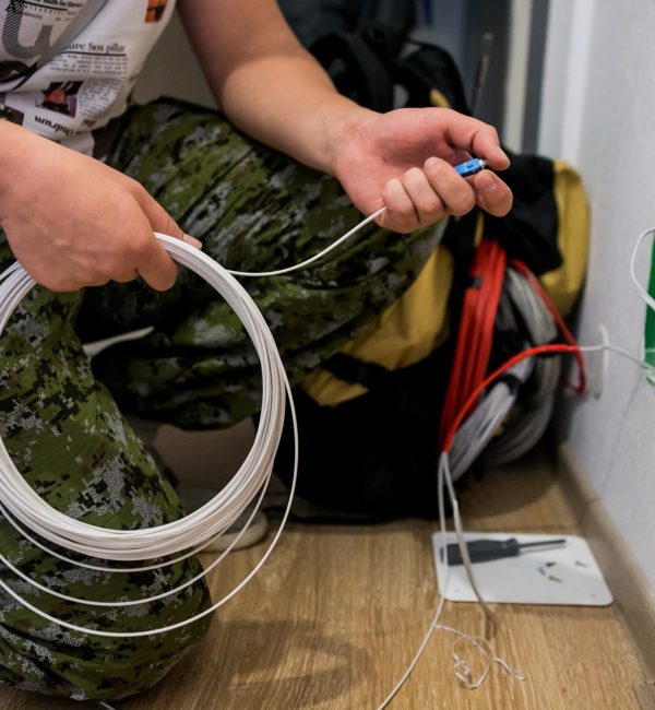 In-Wall Cable Installation for Enhanced Connectivity Technician preparing white in-wall network cables during an installation project with tools and equipment nearby.