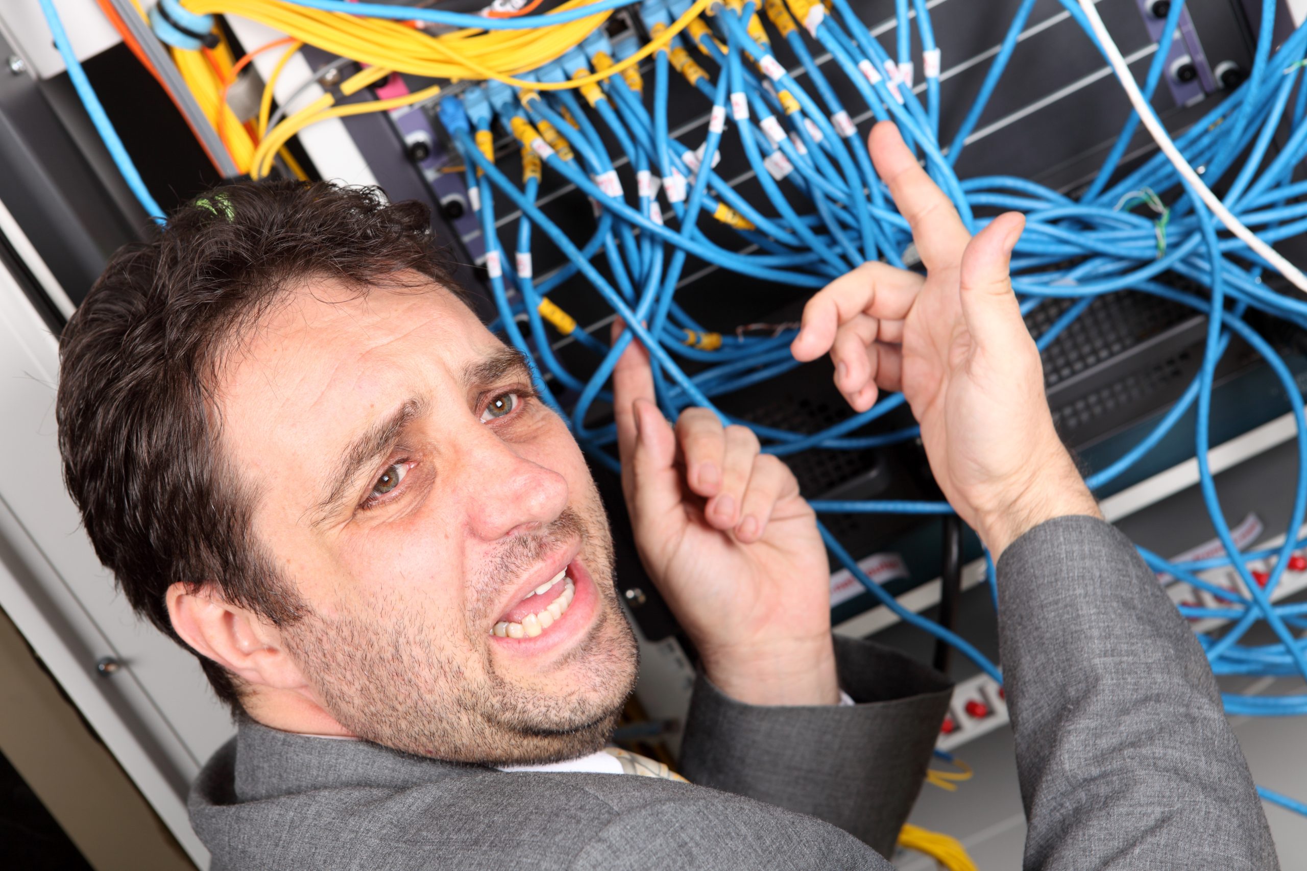 Troubleshooting Messy Network Cables Technician frustrated with messy and tangled network cables in a server rack