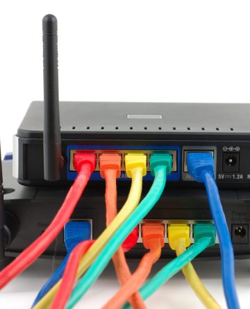 Network Infrastructure Setup A close-up image of a router with multiple Ethernet cables connected to it. The router has two external antennas and is connected to a second device with Ethernet cables.