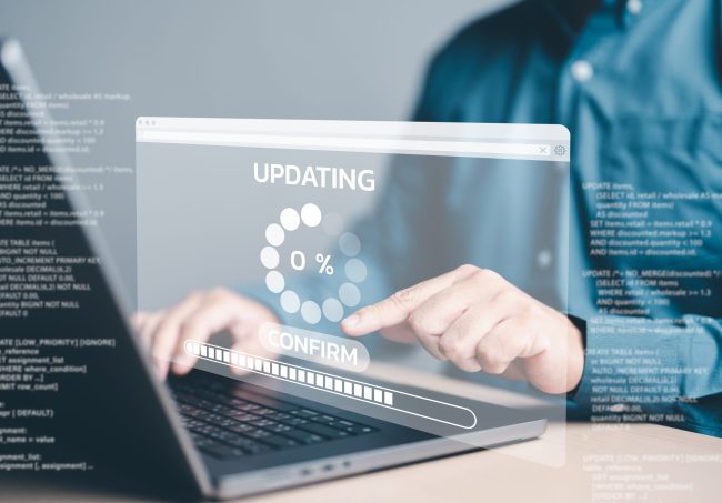 Reliable Software Update and Optimization Services Person interacting with a laptop showing a progress bar for software updates, symbolizing software upgrades and optimization.